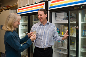 James and Susan Golden talking about a petri dish Susan is holding that contains algae samples