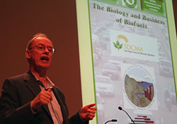 Chris Somerville standing next to a screen giving a talk onstage