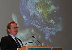 Steve Kay standing next to a screen giving a talk onstage