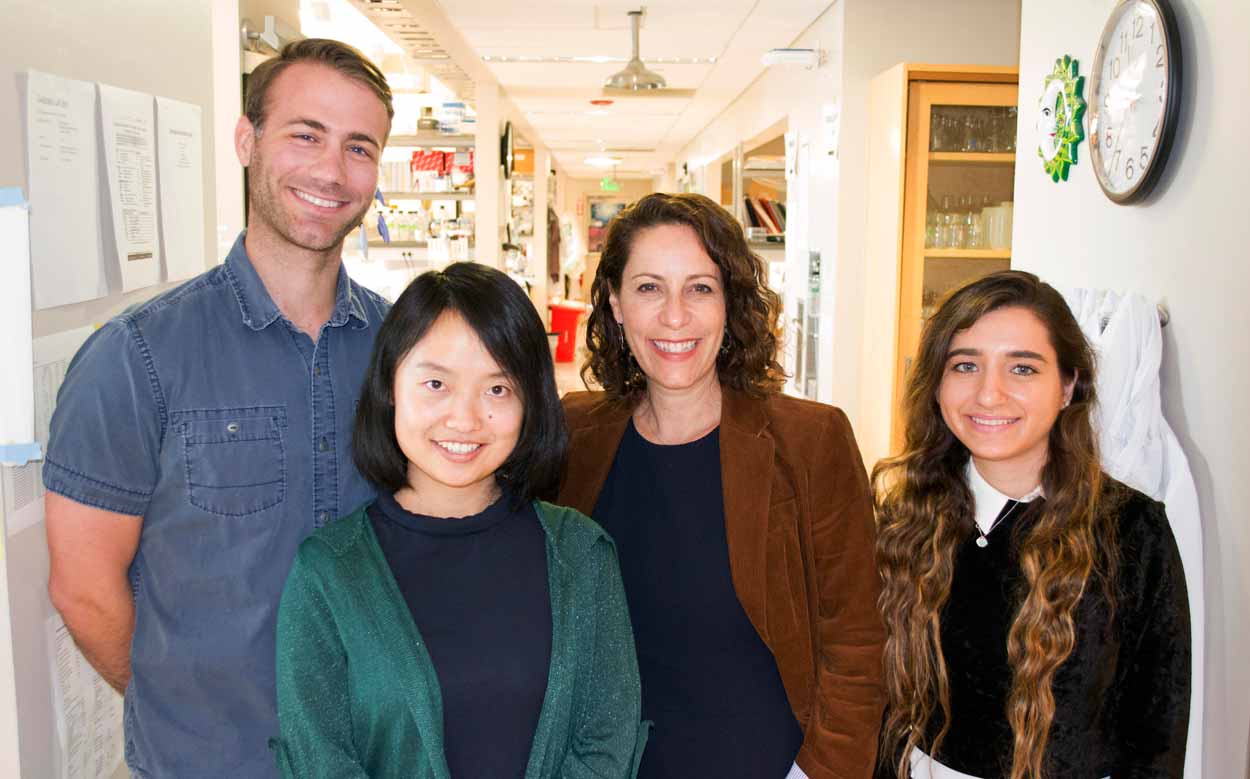 a man and three women pose for a photo in the laboratory hall