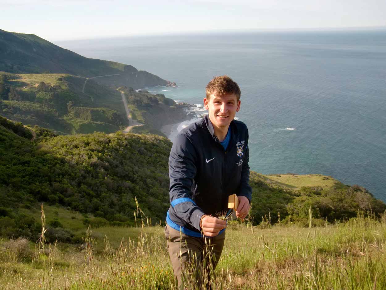 An image of Joseph Waterton collecting seeds and smiling at the camera.