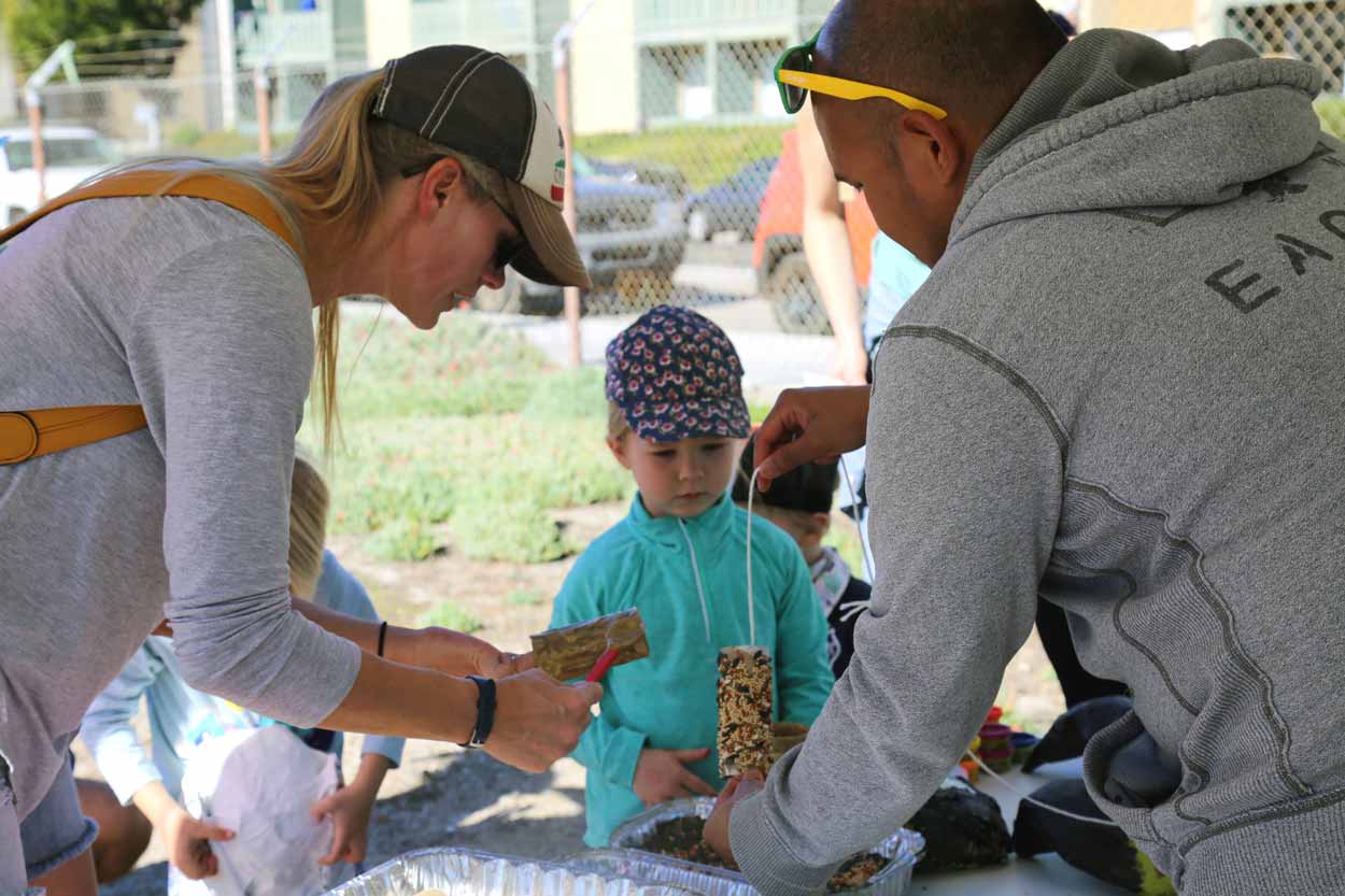 Volunteers helping a young kid with arts and crafts